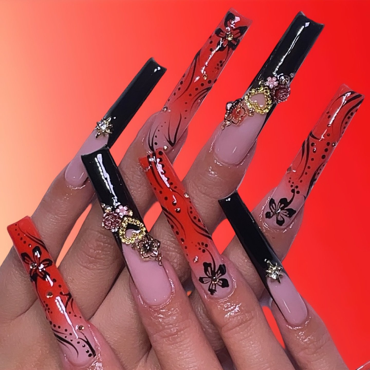  artistic red and black nails with floral designs and gems