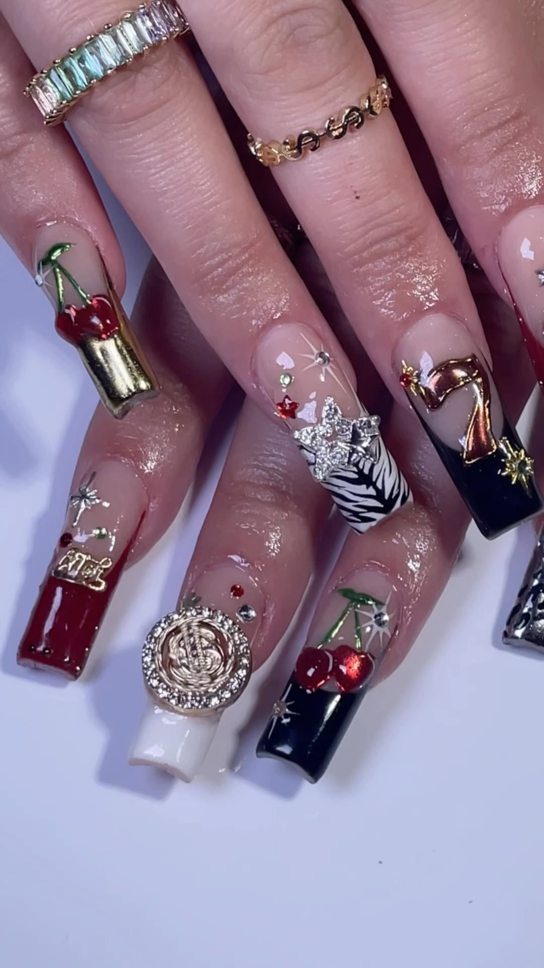 Artistic Nail Design with Cherry and Gold Accents
