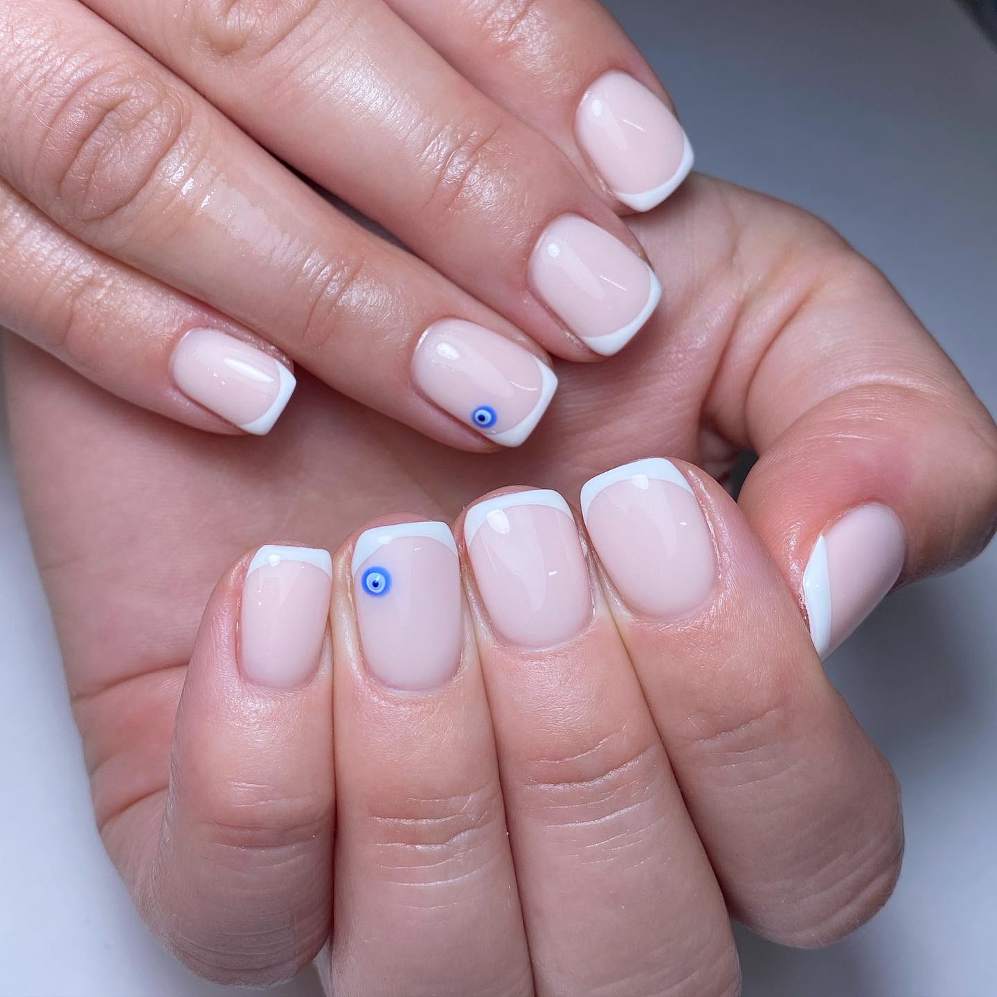 Elegant Nude French Manicure with Blue Eye