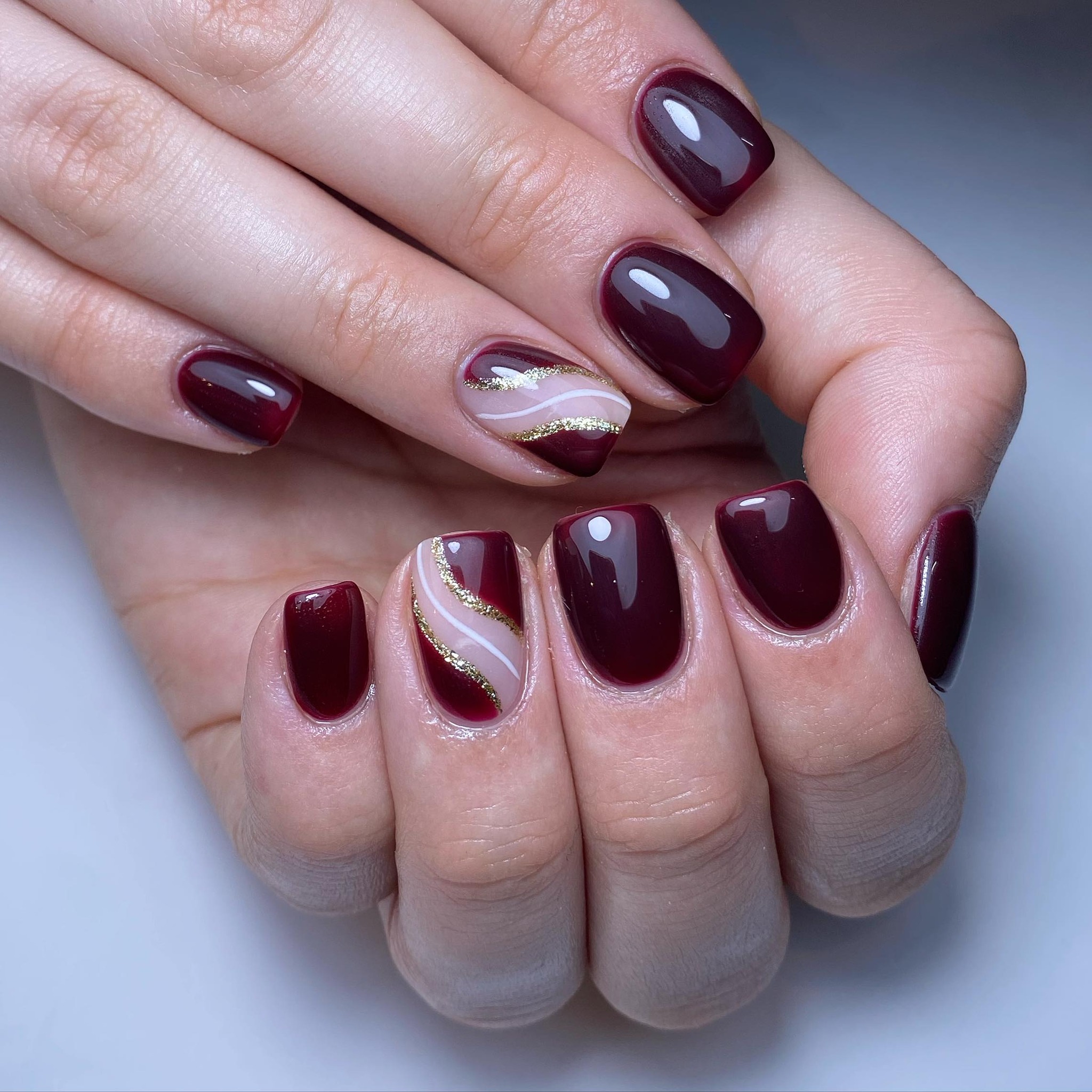 Elegant Burgundy Nails with Gold Accents