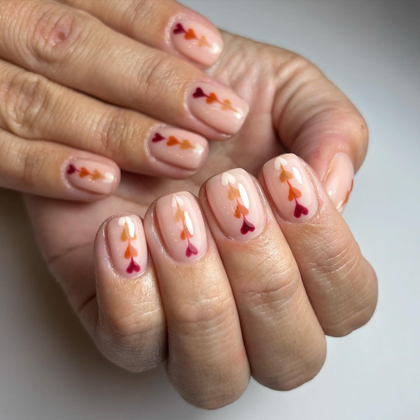 Artistic Nude Nails with Colored Hearts