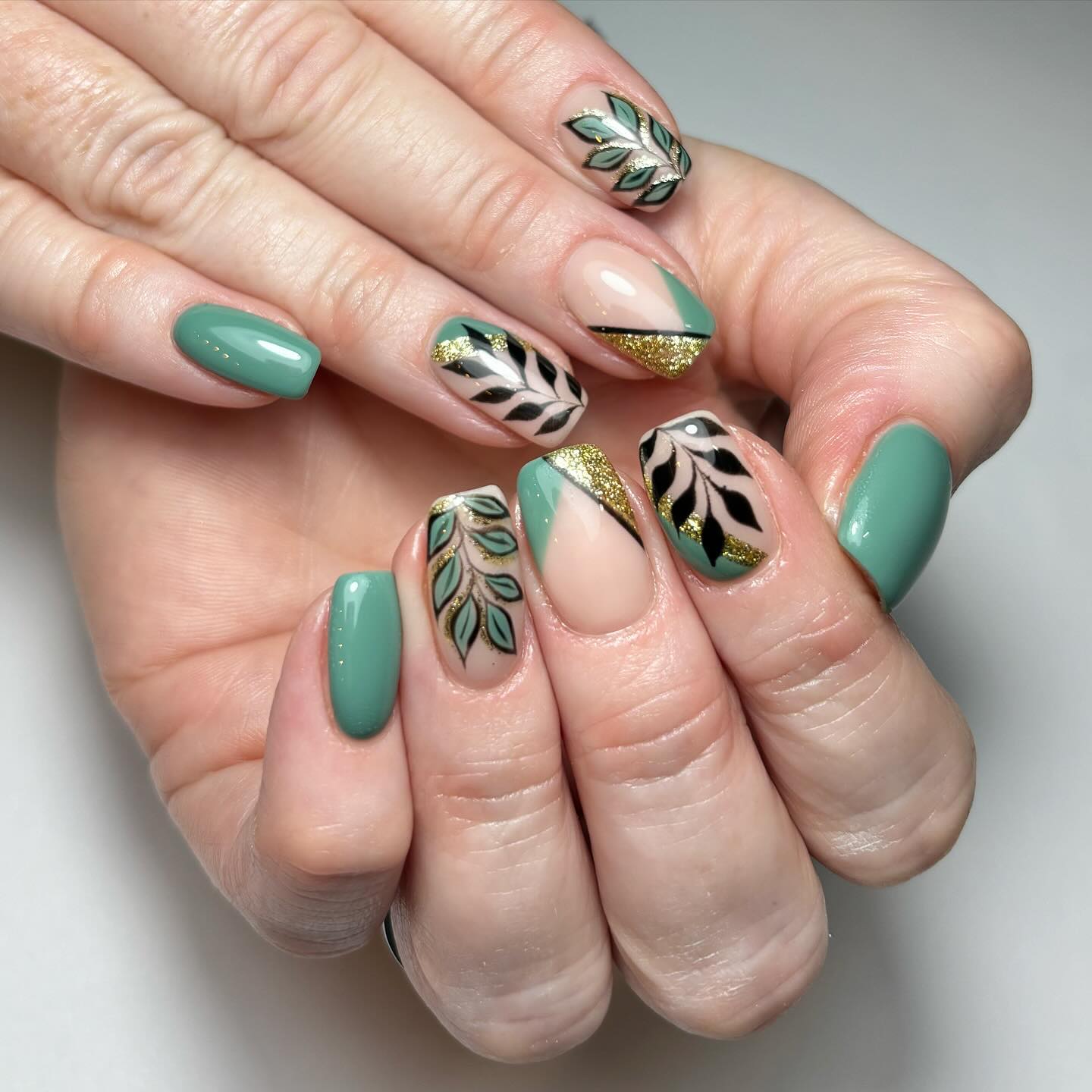 Artistic Green and Gold Nails with Leaf Patterns