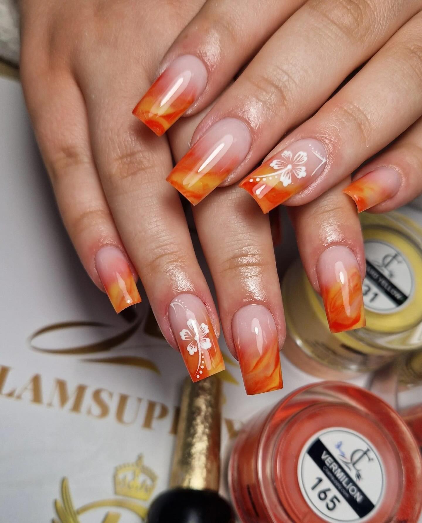 Vibrant Orange Ombre Nails with Floral Design