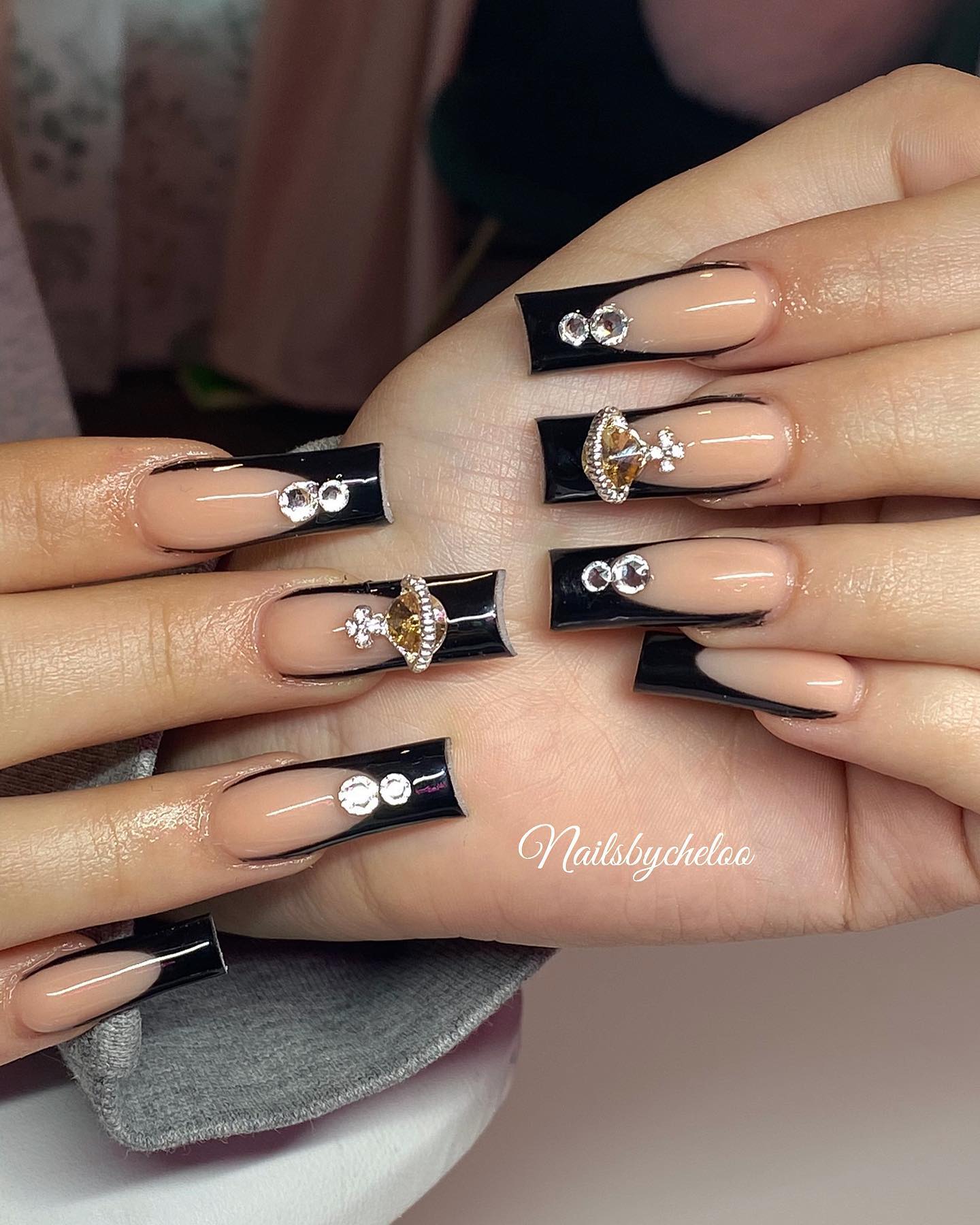 Stylish Black and Nude Nail Design with Gems